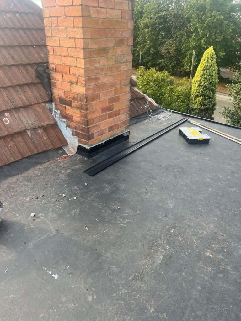 This is a photo of a flat roof which has just been repaired, there is also a chimney stack and some leadwork has also been dressed. Works carried out by Sudbury Roofing Repairs